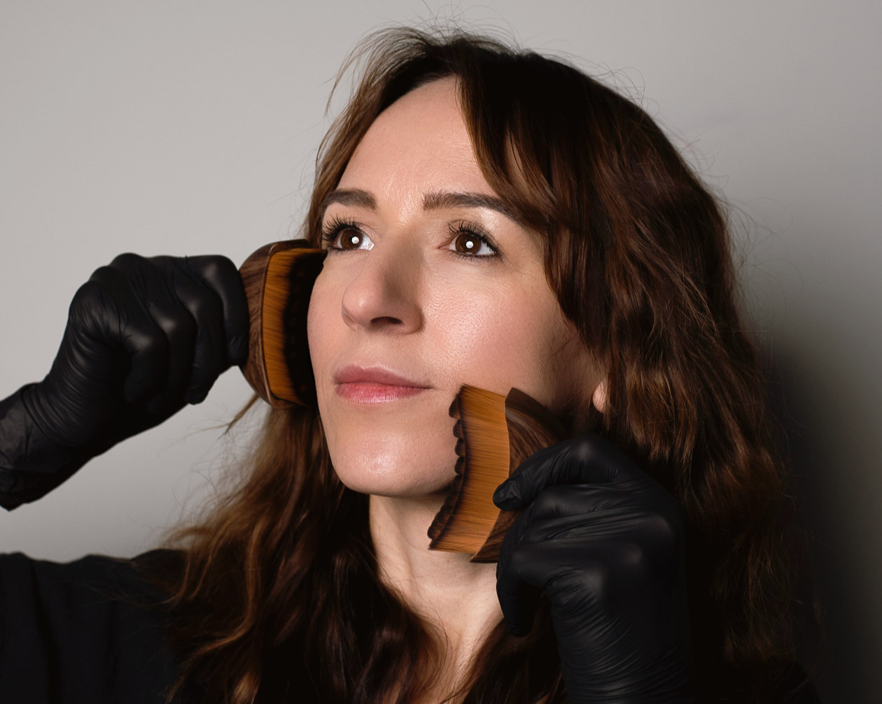 Close-up of a woman receiving facial massage with wooden tools to stimulate circulation and relax facial muscles